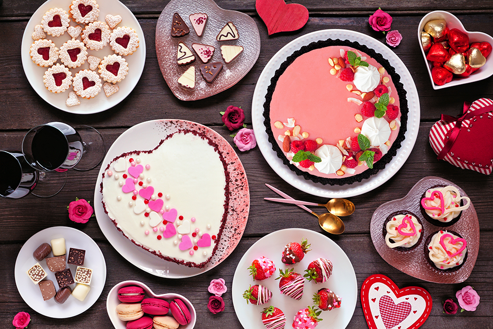Valentines Day table scene with a selection of desserts and swee